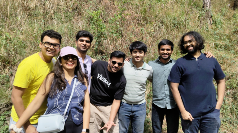 Seven people posing together outdoors on a team outing.